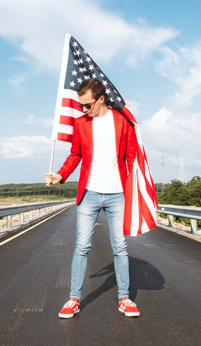 Man Standing in the Road with USA Flag Man Standing in the Road with USA Flag